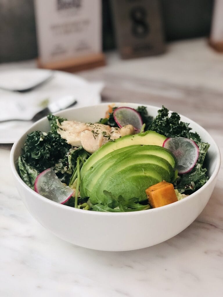 a bowl of salad with avocado and vegetables