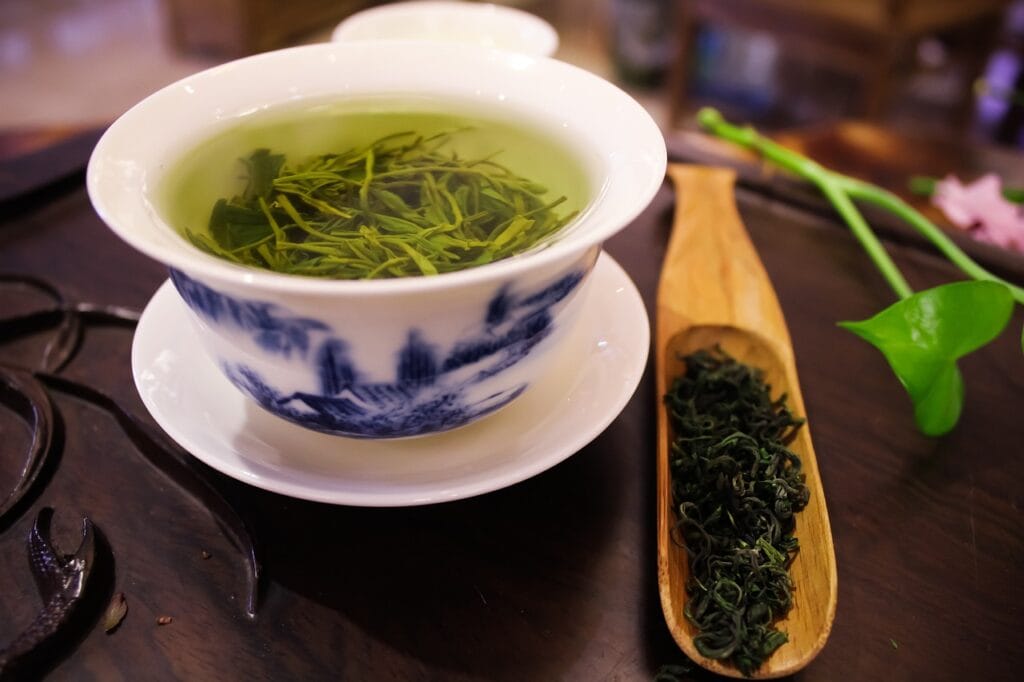 a bowl of green tea with a spoon and a wooden spoon